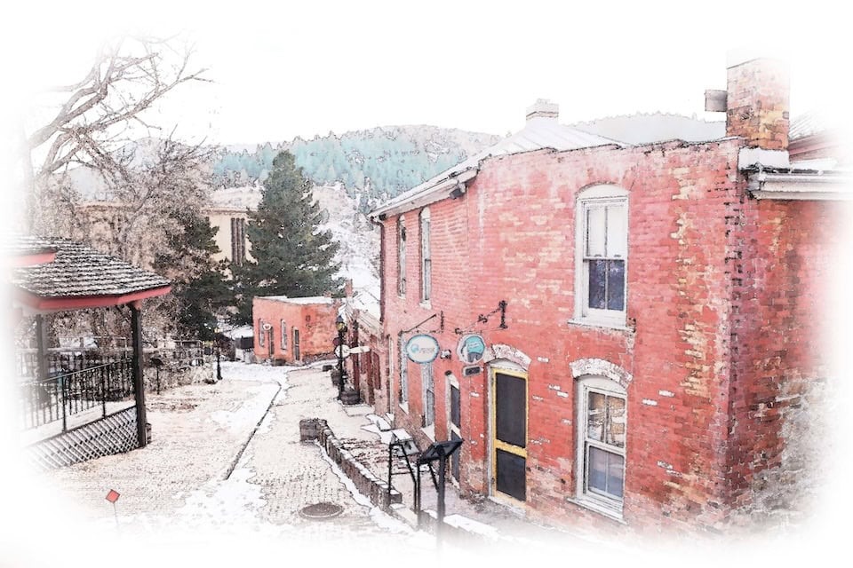 Artistic image of Reeder's Alley, a cobblestone street with red old buildings.