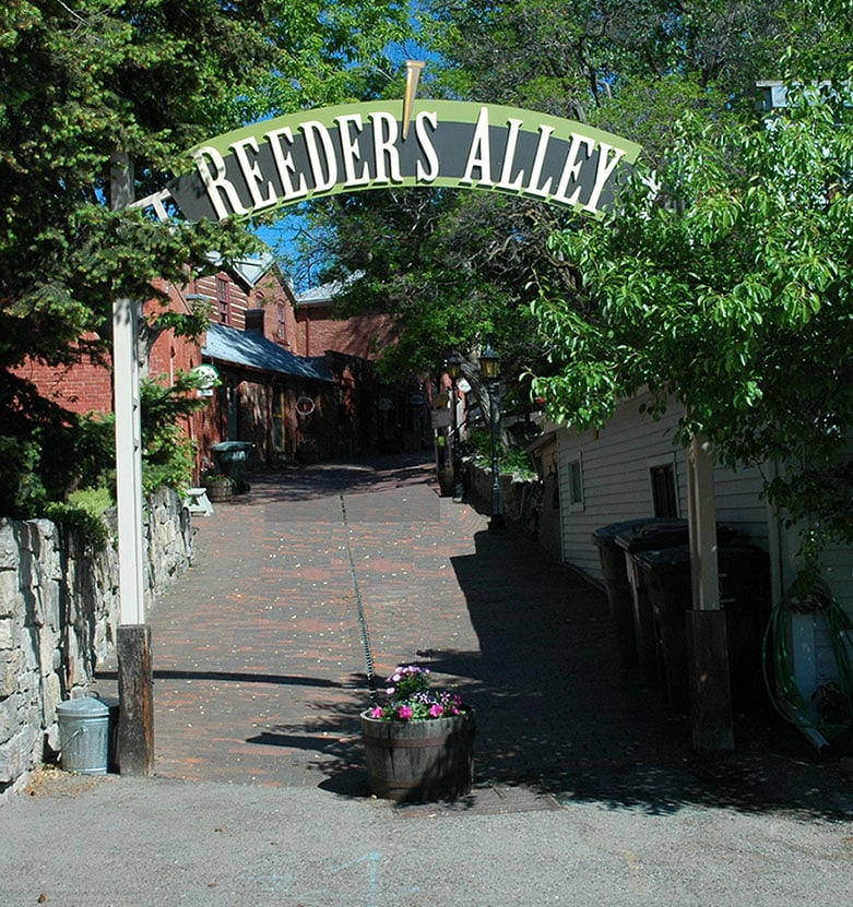 Treelined pathway with an arched sign called Reeders Alley