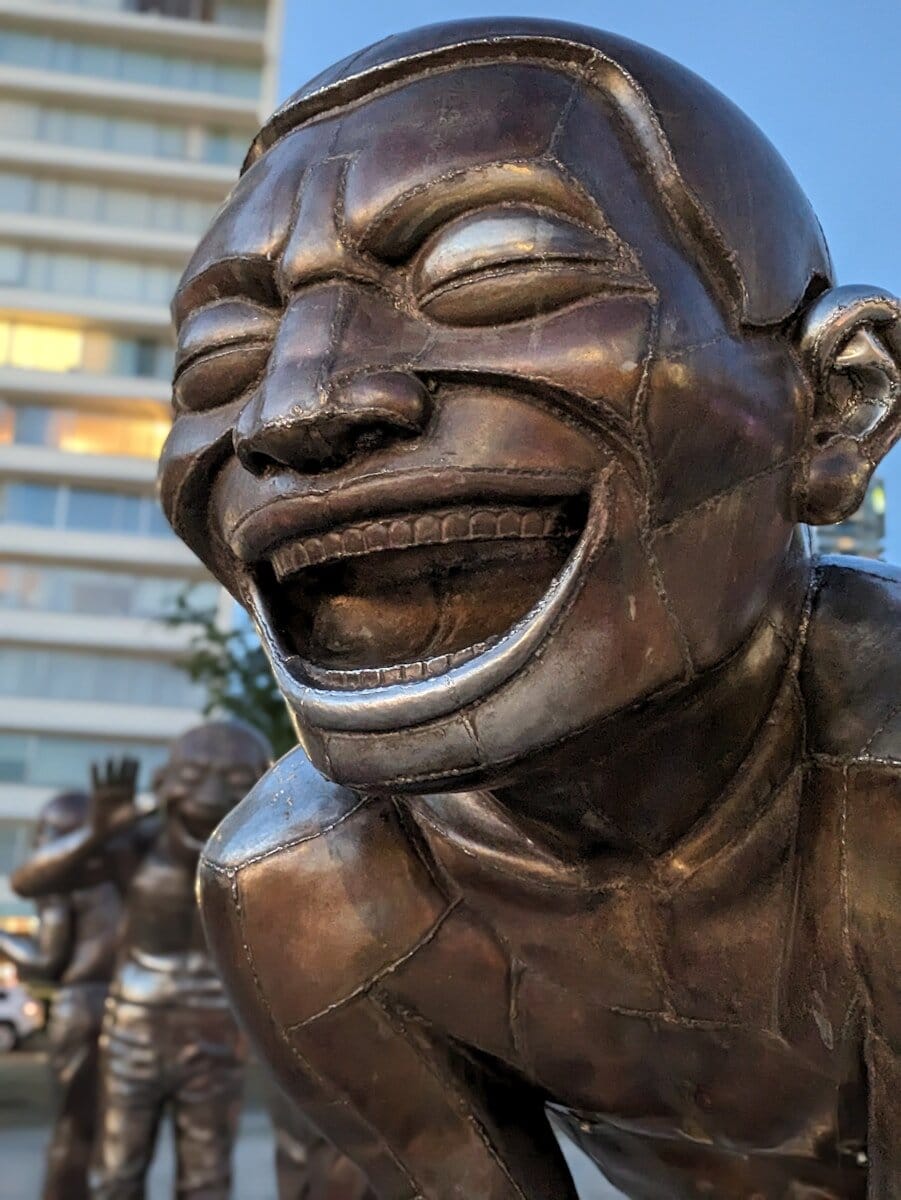A bronze sculpture of a laughing person.